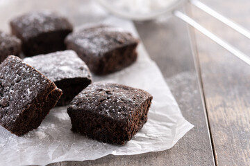 Homemade chocolate brownies with sugar powder on wooden table