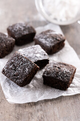 Homemade chocolate brownies with sugar powder on wooden table