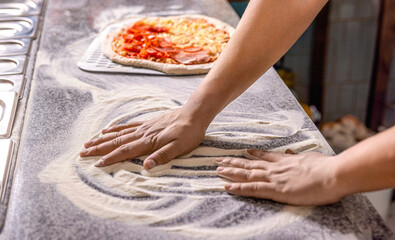 Hands preparing a pizza or making a homemade pepperoni pizza. Cook hand makes a pizza, puts the...