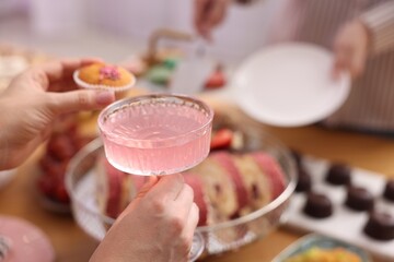 People with drinks and delicious desserts at buffet table, selective focus