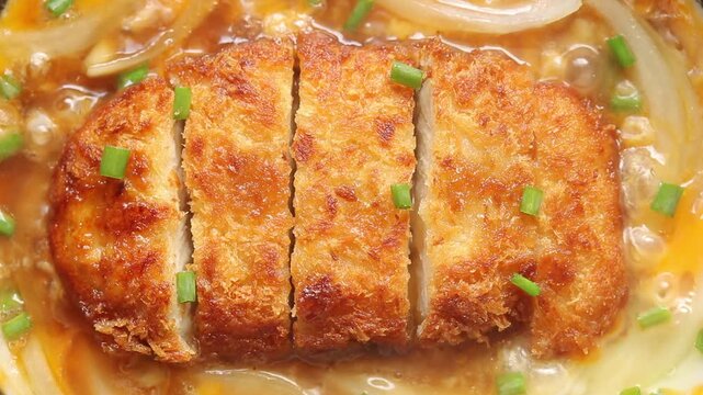 Cooking Pork Cutlet, Egg and Onion and in Hot Pan. This is Katsudon, a Japanese Food