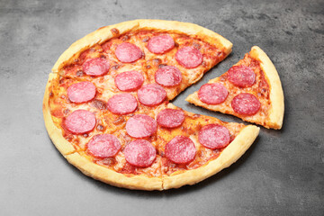 Delicious cut pepperoni pizza on grey table, closeup