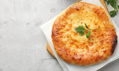 Delicious Megrelian khachapuri with parsley on grey table, top view. Space for text