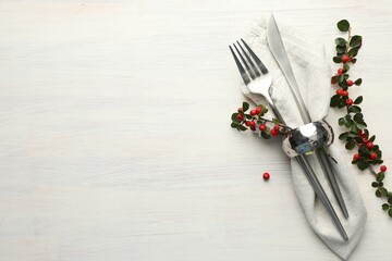 Beautiful table setting. Cutlery with napkin and autumn decor on white wooden background, top view. Space for text