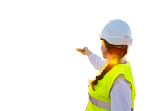 Female engineer using smartphone and supervising construction site at sunset. PNG background