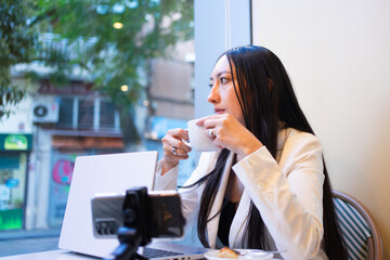 Woman working remotely with laptop at cafe