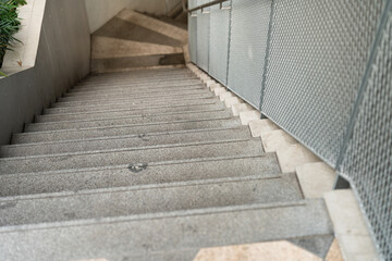 Stairway steps with metal banister going down the lower floor, building place scene photo.