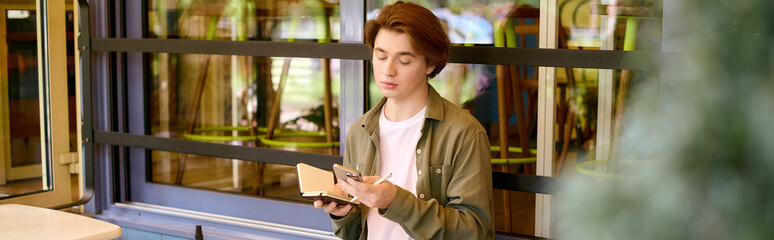 Young man using his phone in a modern cafe setting