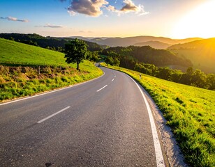 Naklejka premium Winding road through lush green hills, illuminated by warm sunset, inviting travel