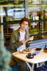 Young man enjoys a delicious meal in a bright modern cafe setting