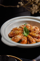 Braised prawns,White tableware for Chinese food in a Chinese restaurant, simple composition with floral background