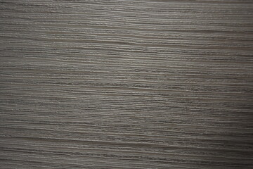 Construction and renovation materials, natural wood background. Gray-brown plastic surface with the texture and relief of wooden planks.