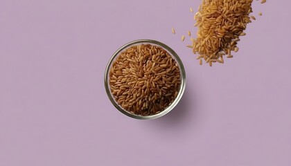 Top view of a small glass bowl filled with brown flax seeds next to a pile of seeds on a pale purple background