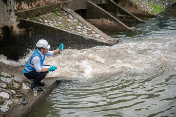 Wastewater treatment worker is collecting samples of water from a public well