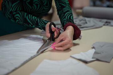 Designer hand sewing clothing pieces