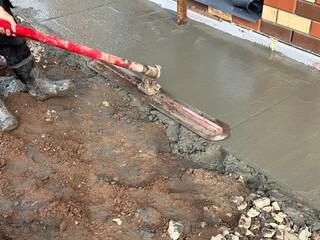 Process of leveling freshly poured concrete. Ironer for concrete. Removing roughness. Filling the...