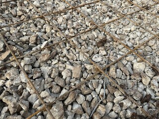 Crushed stone with reinforcing mesh. Preparation for pouring the concrete base. Metal fittings. Concrete slab or blind area
