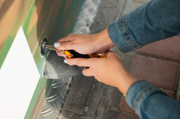 Woman's hands inserting key into mechanism lock