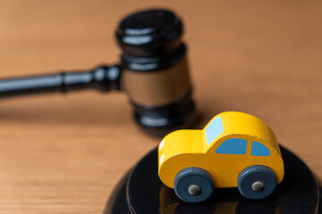 Toy car and a judge’s gavel. Automobile law, insurance claims, legal disputes, traffic court...