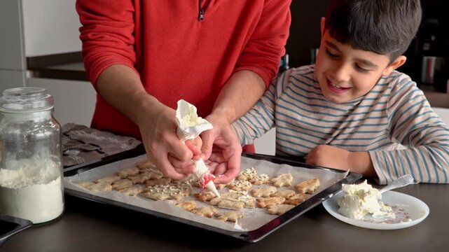 Child helping with the christmas cookie decoration