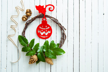 Red Felt Handmade Christmas Ornaments and Holly Leaves on White Wooden