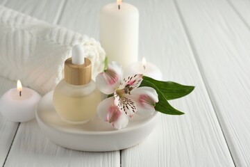 Beautiful spa composition with essential oil and burning candles on white wooden table, closeup. Space for text