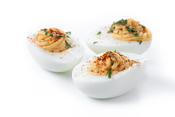 Homemade hard Boiled Deviled Eggs garnished with herbs isolated on white background