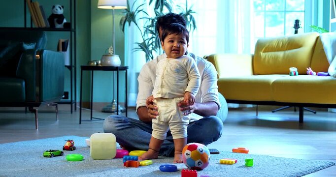 Indian infant baby balancing standing for the first time while father happy witnessing this precious lifetime milestone, filled with love, bonding, joy, and emotional parenting moments in modern home