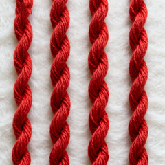 Red braided ropes on white surface