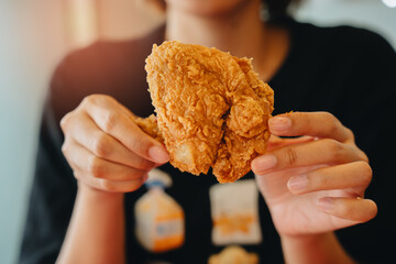 Fried chicken concept. Crispy Fried Chicken Served in Hands Close-Up with Soft Focus Background and Warm Lighting for Food Lovers
