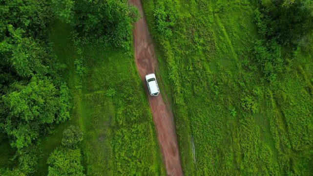 ariel view of following suv  in red soil road drone 
