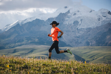 Female runner running on the high altitude grassland mountain top