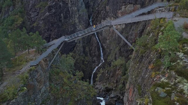 Lush forest surrounds Voringfossen waterfall in aerial perspective