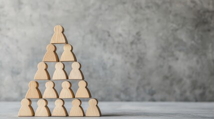 A pyramid of wooden figures symbolizes hierarchy or teamwork against a textured gray backdrop.