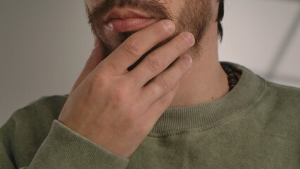 Fototapeta premium A close up view of a man chin and hand, showcasing a thoughtful gesture with a beard.