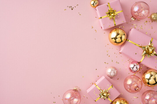 A pink holiday scene with wrapped gifts and gold ribbons, festive ornaments, and confetti for Christmas and New Year celebrations
