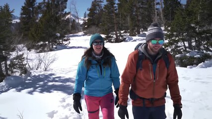 Couple hiking in snowy mountain forest.