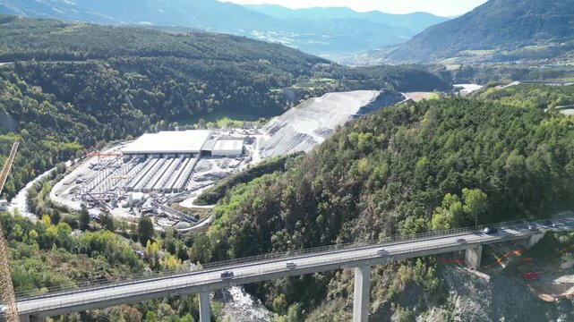 The Brenner Base Tunnel "BBT" construction site in Varna, Alto Adige, with cranes and machinery set against the stunning backdrop of the Alps.