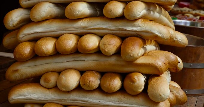 Crispy golden baguettes stacked on a rustic market stand. Freshly baked and inviting - perfect scene from a local farmers market or artisan bakery.