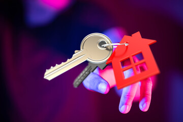 Person holding house keys with house shape keychain concept. Representing home ownership, real estate, new home, property, mortgage and key to a