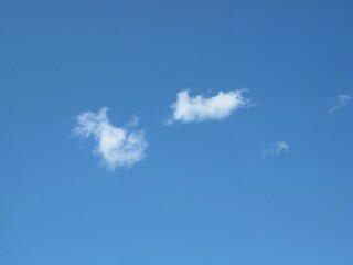 White clouds drifting in a clear blue sky on a sunny day  