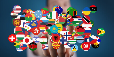 A hand touching a collection of country flags, symbolizing globalism, international relations, and...