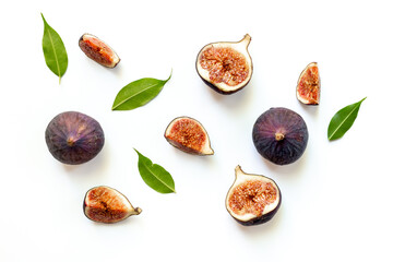Purple ripe figs fruit and slices with green leaves top view on a white background