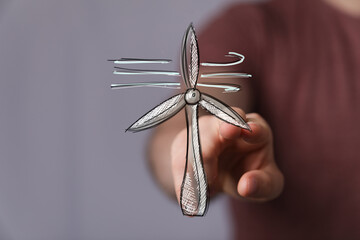 Sketch of wind turbine, clean energy, sustainable power, eco-friendly concept. Hand points at...