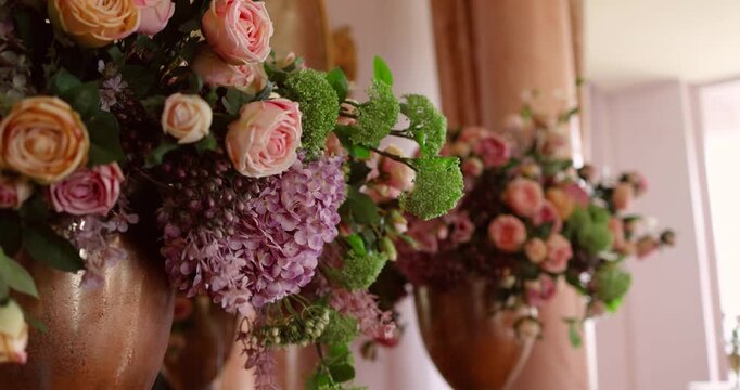 Elegant floral arrangements of roses, lilacs, and mixed flowers in large vases. Concept of decoration, celebration, and beauty.