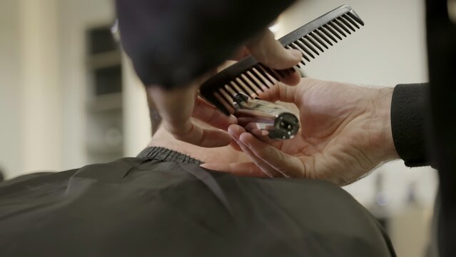 Professional barber cutting hair with electric clipper. Clip