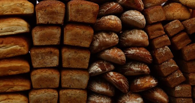 Various types of rustic bread loaves lie side by side. Crusty, golden, handmade, and organic perfect background for bakery or food-related themes.