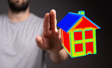 Person touching a digital house model, showing thermal analysis data.  Concept of smart home, energy efficiency and modern property management v