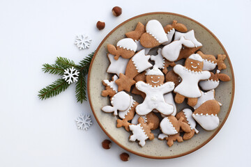 Decorated gingerbread cookies of various shapes on a plate. Christmas baking