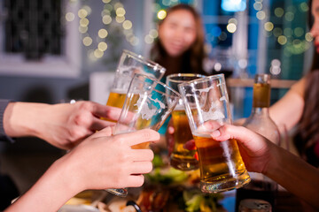 Friends having fun clinking glasses with beer